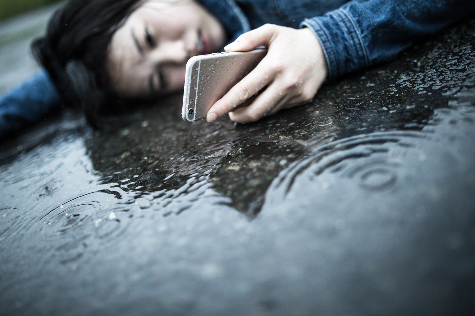 雨の中転ぶ歩きスマホの女性